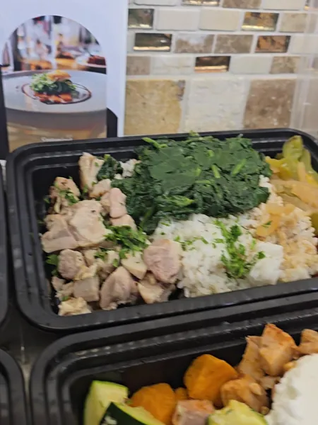 Chicken, rice and greens beside the CFR menu card